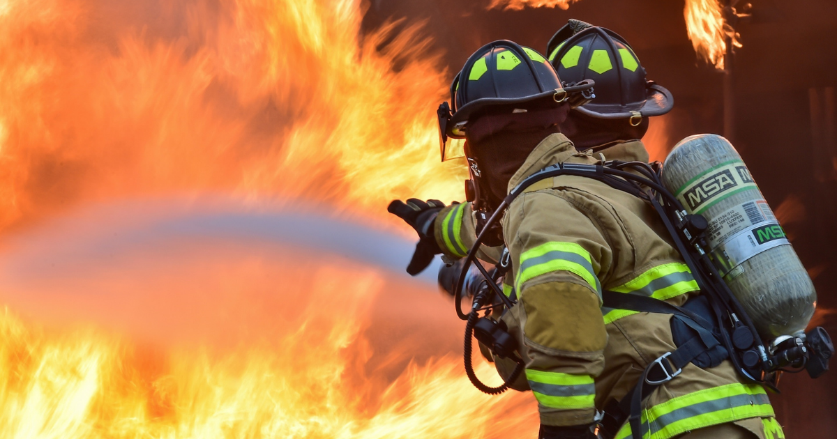 Firefighters spraying water on a fire